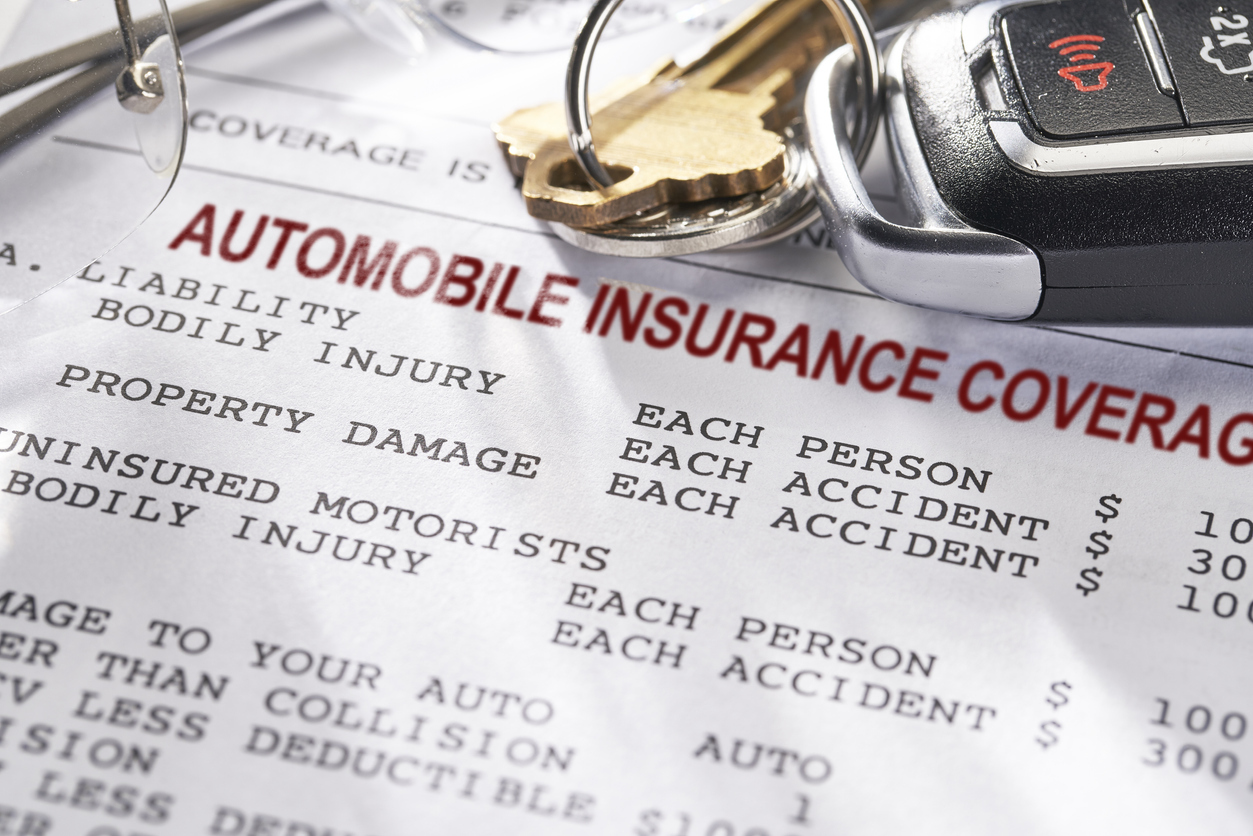 Close-up of an auto insurance policy with car keys on top