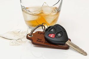 Car keys next to a broken glass of whiskey