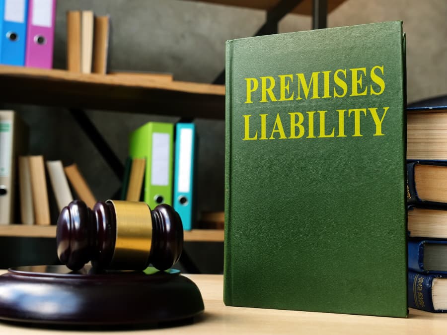 a premises liability book and a gavel laying on a desk