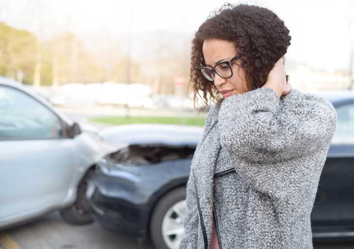 woman rubbing her neck after a car accident