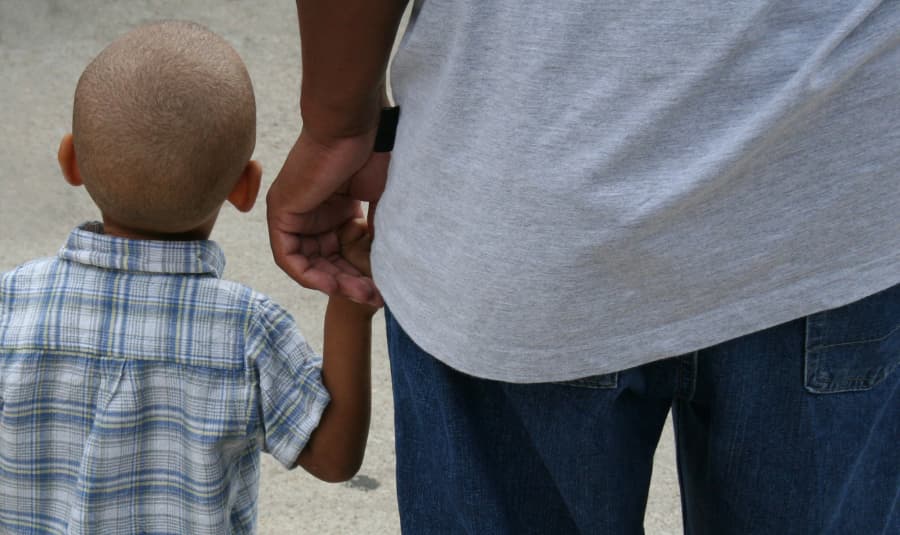 little boy holding his dads hand