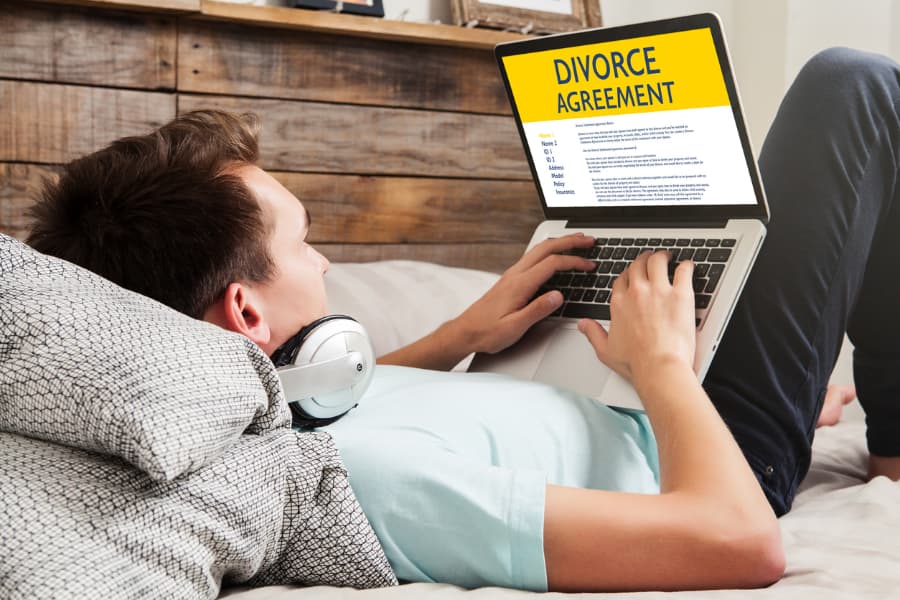 Man with a divorce document on a laptop