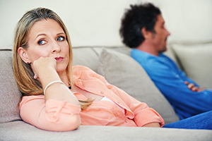 man and woman sitting on opposite ends of couch