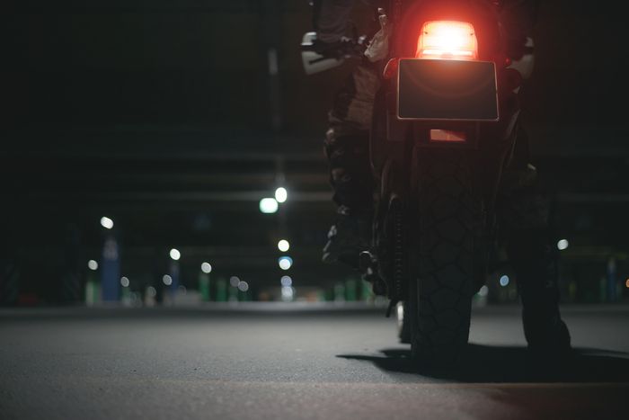 Motorcycle rider sitting on his bike at night in a parking garage
