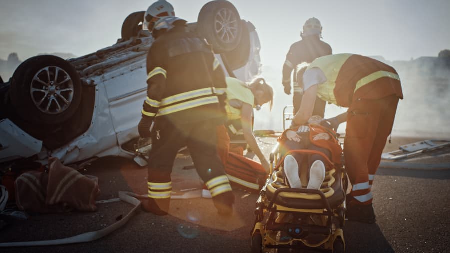 Firefighters rescuing victim on scene of motor vehicle accident