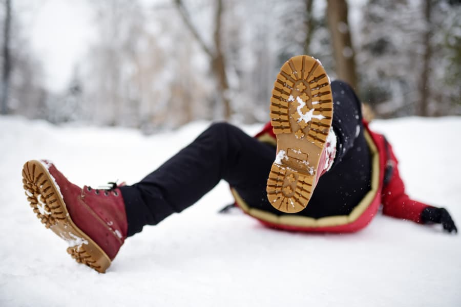 woman who’s fallen on a snowy sidewalk