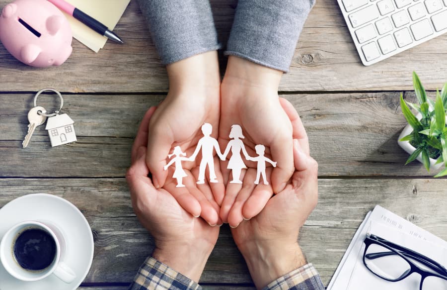 Cupped hands holding cutout of family