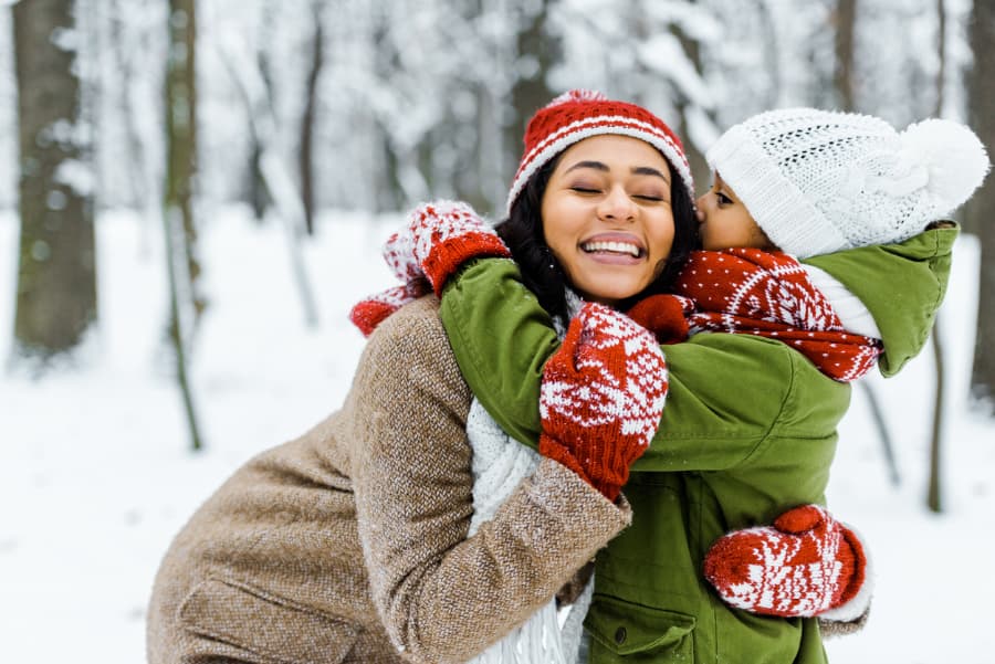 Little girl hugging mom in the snow