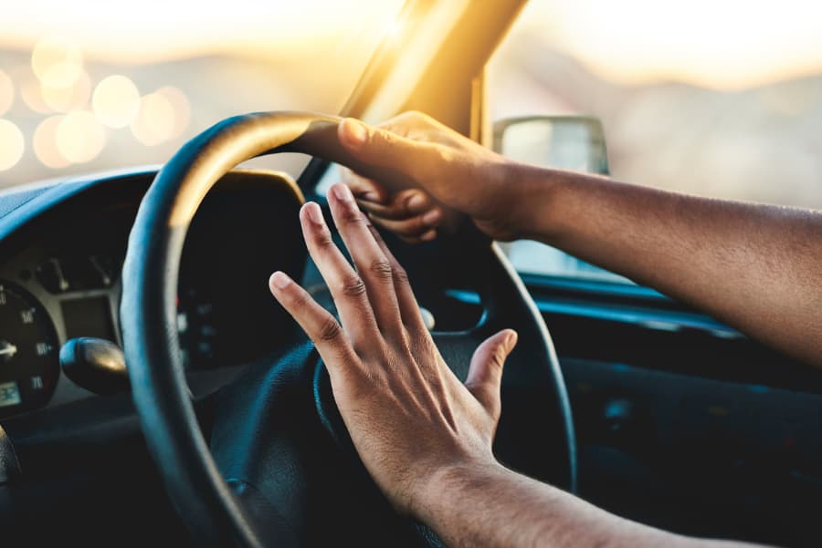 Cropped shot of an unrecognizable man honking his car horn