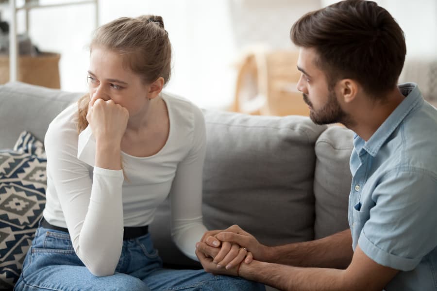 Man Holding Hands Of Crying Wife