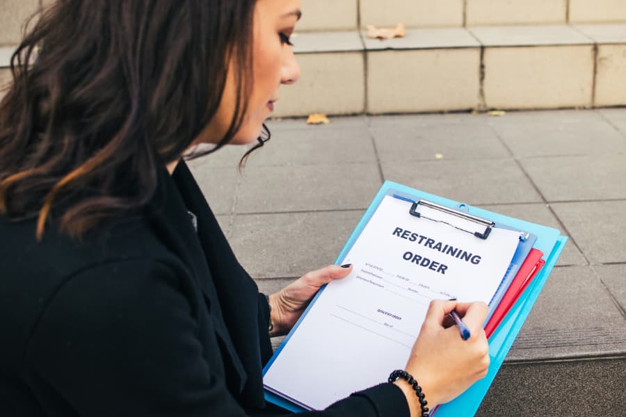 Woman filling out a form for a restraining order request