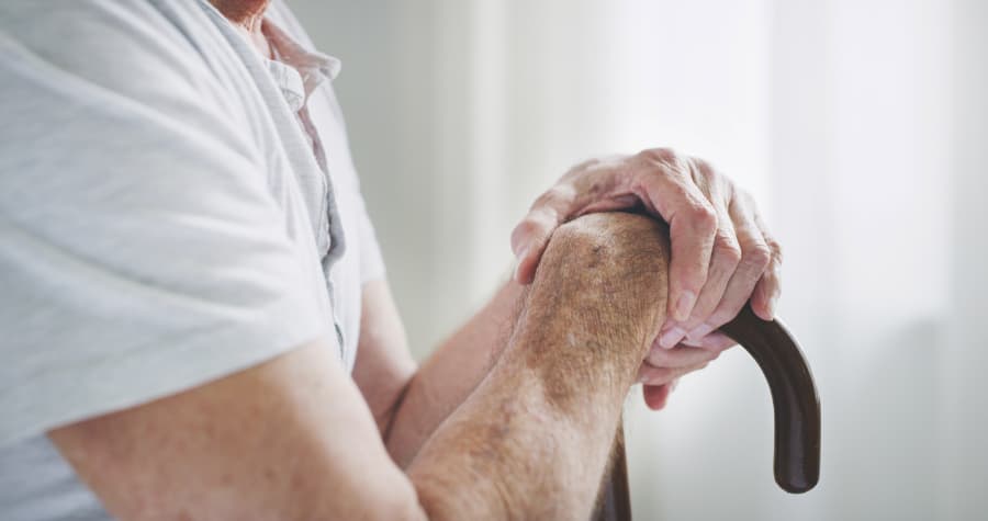 Close-up of a senior man gripping a cane 