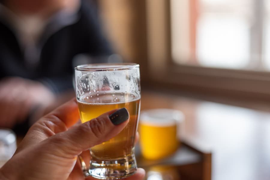 A close-up of a woman holding a glass of beer