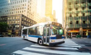 Blurred image of a city bus turning into a crosswalk