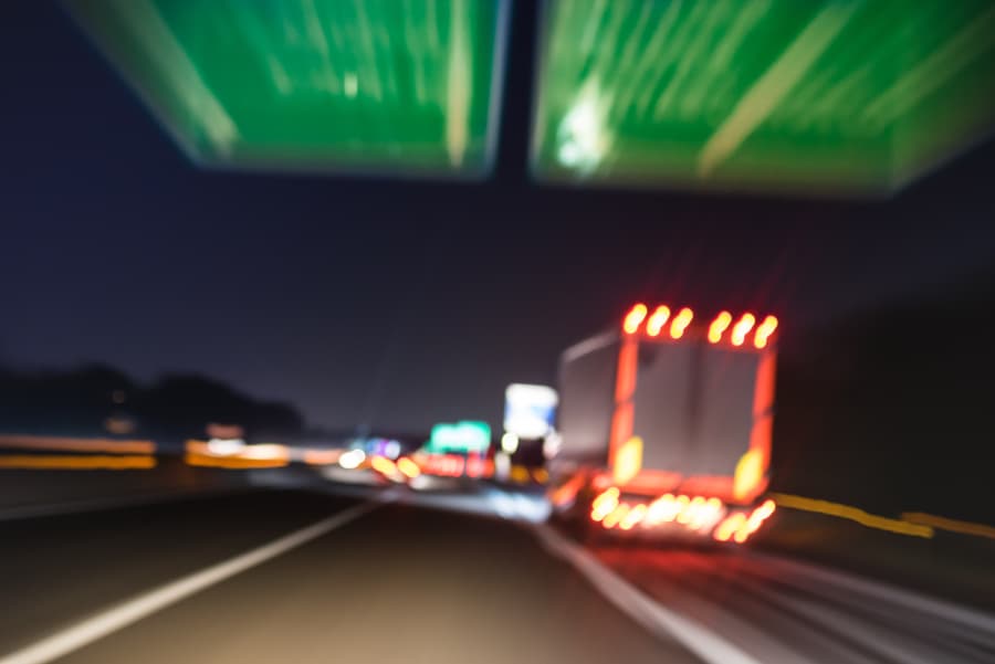 Blurred rear view of a semi-truck on the highway at night